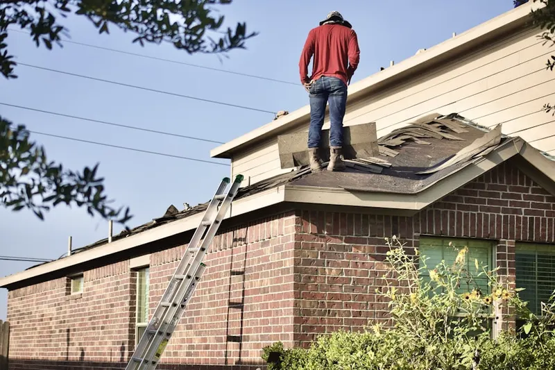 Professional roofer working on a residential roof in Enola